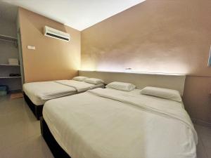 twee bedden in een ziekenhuiskamer met witte lakens bij De UPTOWN Hotel @ Damansara Uptown in Petaling Jaya