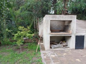a concrete oven in a yard next to a fence at Chacras casa Armonia in Chacras de Coria