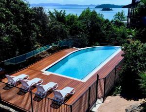 a swimming pool on a deck with chairs around it at Casuarina 16 - 3 Bedroom House With 180 Degree Ocean Views, Buggy & Valet Service in Hamilton Island