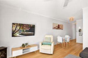 a white living room with a table and chairs at Avilla Court Stunning Views in The Entrance