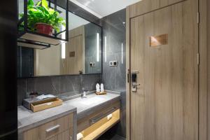 a bathroom with a sink and a mirror at Morning Hotel, Changsha Langli in Changsha +27 photos