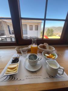 a table with a plate of food and a glass of orange juice at Atoq San Blas Hotel in Cusco
