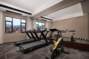 a gym with two treadmills and two exercise bikes at Till Bright Hotel, Loudi Shuangfeng in Shuangfeng