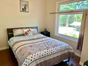 a bedroom with a bed and a large window at New & Cozy Niagara Getaway. 7 mins from the Falls in Niagara Falls