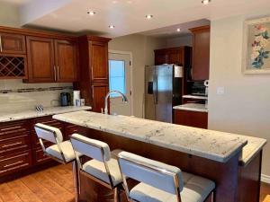 a kitchen with a large island with bar chairs at New & Cozy Niagara Getaway. 7 mins from the Falls in Niagara Falls