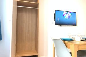 een kamer met een houten deur, een tafel en een televisie bij M2 Cosy studio RER BC500m Orly 20 min Netflix in Massy
