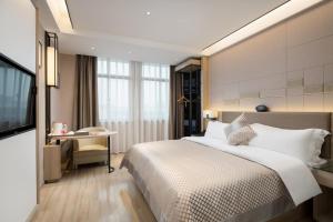 Habitación de hotel con cama grande y escritorio. en Morning Hotel, Changsha Langli, en Changsha