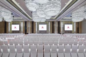 a conference room with white chairs and two screens at Zhuzhou Marriott Hotel in Zhuzhou
