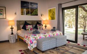 a bedroom with a bed and a large window at Exbury Wild in Hoedspruit