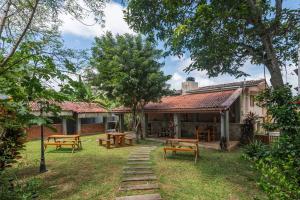 a house with picnic tables and benches in the yard at Beverly Suites Mount Lavinia in Mount Lavinia