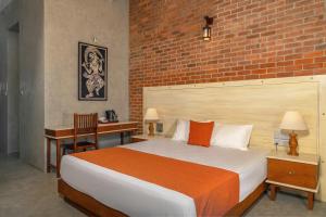 a bedroom with a bed and a brick wall at Beverly Suites Mount Lavinia in Mount Lavinia