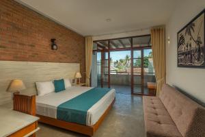 a bedroom with a bed and a couch at Beverly Suites Mount Lavinia in Mount Lavinia