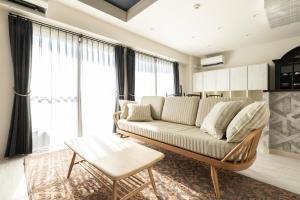 a living room with a couch and a table at ルグランみしま Private lodging in Hamamatsu
