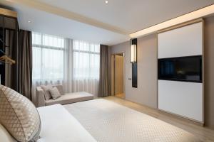 a hotel room with a bed and a flat screen tv at Morning Hotel, Changsha Langli in Changsha