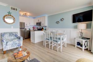 een woonkamer en een keuken met een tafel en stoelen bij 0304 Bountiful Bliss by Atlantic Towers in Carolina Beach