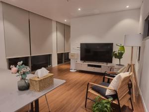 a living room with a television and a table and chairs at Namhae Bay 591 in Namhae