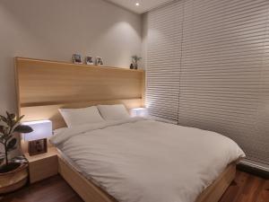 1 dormitorio con 1 cama blanca grande y 2 lámparas en Namhae Bay 591, en Namhae