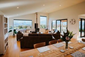 a living room with a couch and a table at On The Rocks - Sleeps 8 - Family Friendly Holiday Home in Paraparaumu Beach