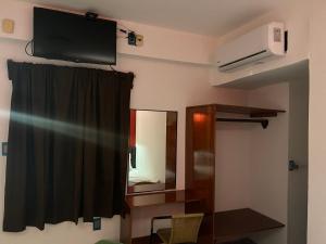 Habitación con TV, espejo y cortina. en Hotel Jar8 Bule en Boca del Río