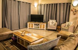 Una sala de estar con un sofá y un televisor. en Buhala @ 411, en Hoedspruit