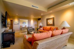 ein Wohnzimmer mit orangefarbenen Sofas und ein Wohnzimmer in der Unterkunft Kapalua Golf Villa 16V 2 in Kahana