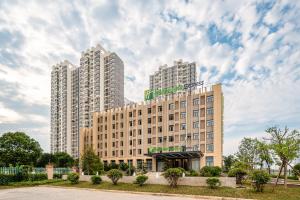 a hotel with two tall buildings in the background at Holiday Inn Express Jurong Xianlin in Zhenjiang