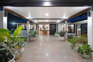 un couloir avec des plantes en pot dans une maison dans l'établissement The Orchard House - Luxury Villa on a Sprawling Tropical Acreage, à Redlynch
