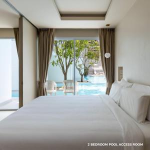 1 dormitorio con cama y vistas a la piscina en Prima Hotel Pattaya, en Norte de Pattaya