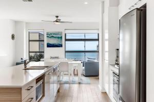 a white kitchen with a view of the ocean at Stunning Sea Views in Excellent Location in Victor Harbor