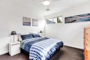 a white bedroom with a bed and a window at Stunning Sea Views in Excellent Location in Victor Harbor