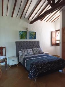 a bedroom with a bed with a blue comforter at cabañas villa Angelica in Barichara