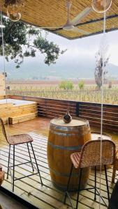 a large barrel sitting on a deck with two chairs at Apalta Lofts, disfruta frente a viñedos in Santa Cruz