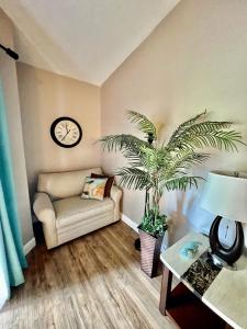 a living room with a couch and a clock on the wall at Dream Vacation Lovely Condo minutes from Beach King bed Heated pool Gym in Clearwater