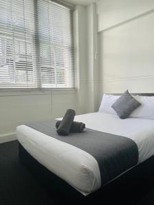 ein Schlafzimmer mit einem großen Bett und einem Telefon darauf in der Unterkunft Gamma Hotel in Auckland