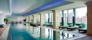 uma grande piscina num edifício com janelas em The Ritz-Carlton Beijing em Pequim