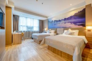 um quarto de hotel com duas camas e um quadro na parede em Morning Hotel, Chenzhou Railway Station em Chenzhou