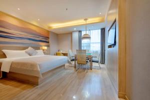 a bedroom with a bed and a dining room at Morning Hotel, Chenzhou Railway Station in Chenzhou