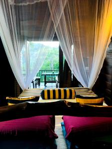 Habitación con 2 camas, cortinas y ventana. en Madushanka Resort, en Ella