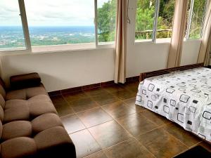 a living room with a couch and two windows at Finca la Aurora in Villavicencio