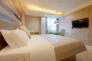 a hotel room with a bed and a dining room at Morning Hotel, Chenzhou Railway Station in Chenzhou