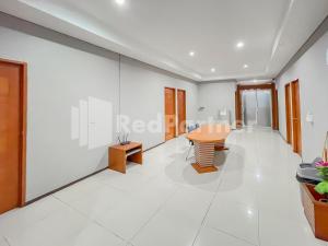 een kamer met witte muren en een tafel en stoelen bij Sang Surya GuestHouse Syariah Near RS Hasan Sadikin Mitra RedDoorz in Bandung