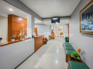 um corredor de um escritório com cadeiras e uma recepção em Sang Surya GuestHouse Syariah Near RS Hasan Sadikin Mitra RedDoorz em Bandung