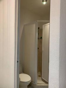 La salle de bains blanche est pourvue d'une douche et de toilettes. dans l'établissement Casa de Cielo y Mar en Cancún, à Cancún