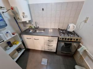 a small kitchen with a stove and a sink at Departamento por día in Río Gallegos