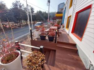 una terraza de madera con macetas en un edificio en Vernia, en Yeosu