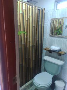 La salle de bains est pourvue de toilettes et d'un rideau de douche en bambou. dans l'établissement Chalet Laguna Sagrada de Fuquene, à Fúquene