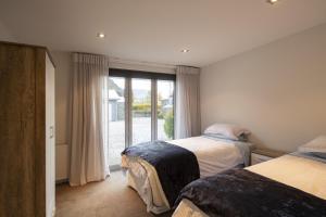a bedroom with two beds and a large window at 61 Gibbston Valley in Gibbston