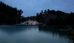 a house sitting on the side of a river at night at Namhae Bay 591 in Namhae