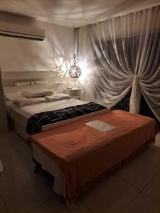 Un dormitorio con una cama grande con una cortina en Bangalô Villas do Pratagy 1 Dormitório e Varanda en Maceió