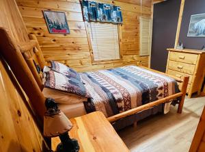 1 dormitorio con 1 cama en una cabaña de madera en Smoky Mountain Enchanting Haven 3BR2BA Cabin en Sevierville